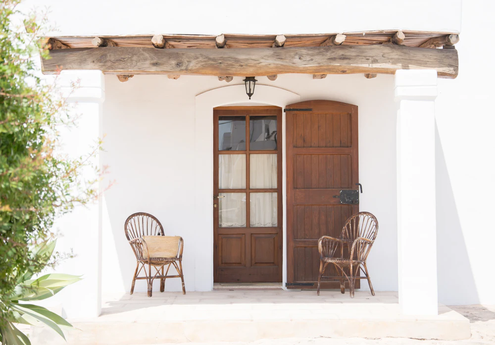 Two cane armchairs outside a wooden door