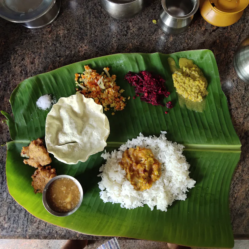 A South Indian lunch on banana leaf with rice, appalam and curries