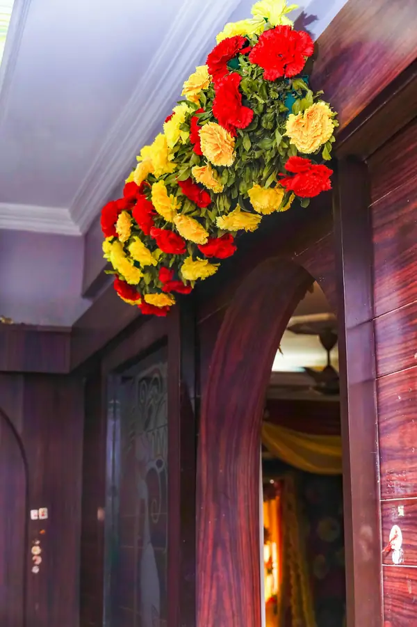 A doorway framed with red and yellow flowers